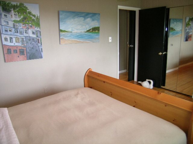 Furnished bedroom with wooden bunk beds and coastal artwork on the wall. - 470 Ellis Street, North Vancouver