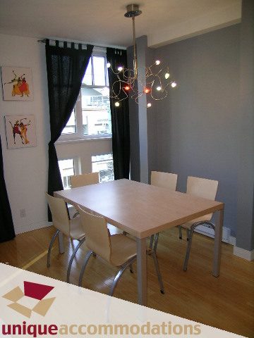 Furnished dining area with modern chandelier, hardwood floors, and city view. - 409 - 1072 Hamilton Street, Vancouver Downtown