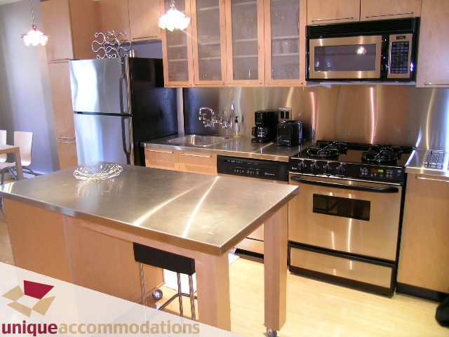 Bright kitchen with stainless steel countertops, hardwood floors, and modern appliances. - 409 - 1072 Hamilton Street, Vancouver Downtown