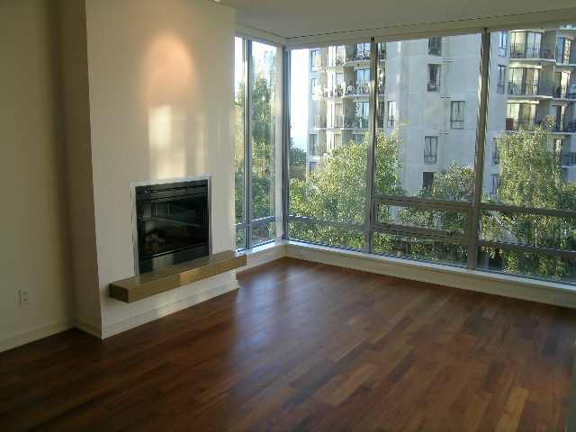 Bright living room with hardwood floors, city view, and modern fireplace. - 505 - 1005 Beach Avenue, Vancouver Downtown