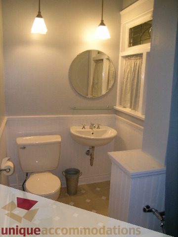 Furnished bathroom with white sink, round mirror, and bathtub. - 3 - 2812 Yukon, Vancouver West Side