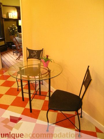 Furnished living area with glass coffee table, checkered floor, and yellow walls. - 3 - 2812 Yukon, Vancouver West Side
