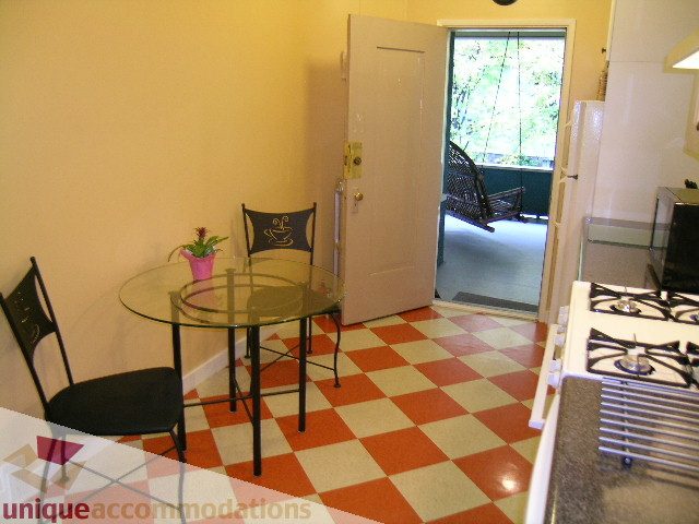 Bright kitchen with checkered floor, glass table, and outdoor view. - 3 - 2812 Yukon, Vancouver West Side