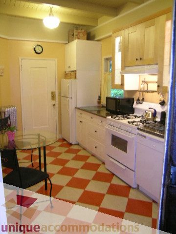 Bright kitchen with checkered floor, white cabinets, and stainless steel appliances. - 3 - 2812 Yukon, Vancouver West Side