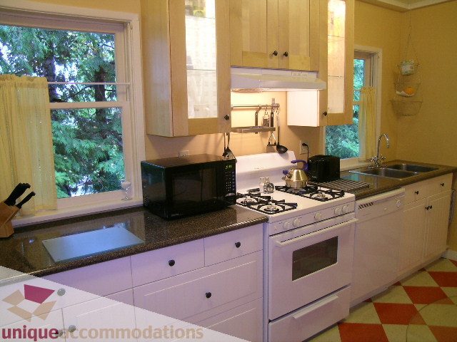 Bright kitchen with white cabinets, granite countertops, and checkered floor. - 3 - 2812 Yukon, Vancouver West Side