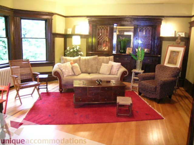Furnished living room with hardwood floors, large bay window, and dark wood furniture. - 3 - 2812 Yukon, Vancouver West Side