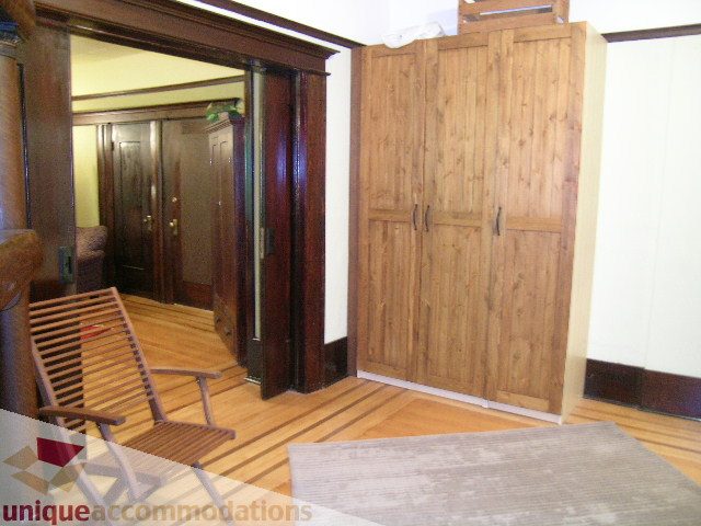 Furnished bedroom with wooden furniture and hardwood floors. - 3 - 2812 Yukon, Vancouver West Side