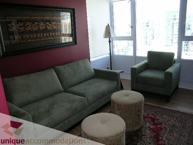 Furnished living room with city view, plush seating, and patterned ottoman. - 3607 - 1033 Marinaside Crescent, Vancouver Downtown