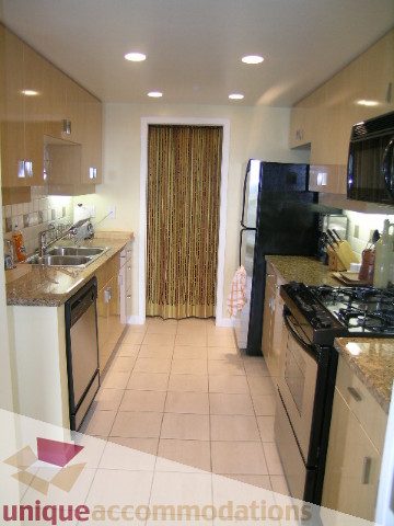 Bright kitchen with granite countertops and stainless steel appliances, clean and modern design. - 3607 - 1033 Marinaside Crescent, Vancouver Downtown