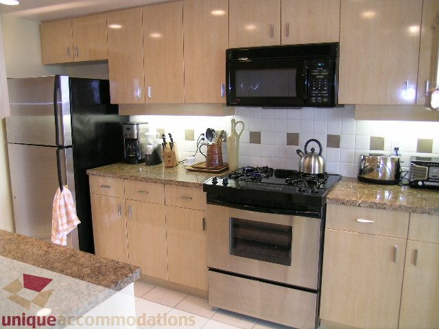 Bright kitchen with granite countertops, stainless steel appliances, and light wood cabinets. - 3607 - 1033 Marinaside Crescent, Vancouver Downtown