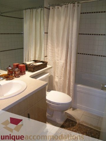 Furnished bathroom with white countertop and tiled walls. - 3607 - 1033 Marinaside Crescent, Vancouver Downtown
