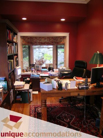 Spacious home office with hardwood floors, a large window, and a cozy desk setup. - 4497 Marine Dr., West Vancouver
