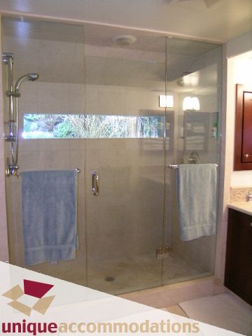 Bright bathroom with glass shower, modern fixtures, and a view of the outdoors. - 4497 Marine Dr., West Vancouver