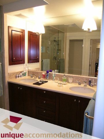 Furnished bathroom with dark wood cabinets and white countertops. - 4497 Marine Dr., West Vancouver