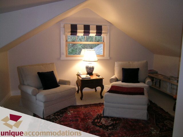 Bright attic room with cozy white armchairs and patterned rug. - 4497 Marine Dr., West Vancouver