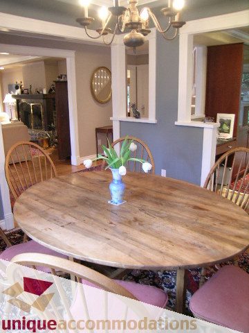 Dining area with rustic wooden table and chairs, chandelier above. - 4497 Marine Dr., West Vancouver