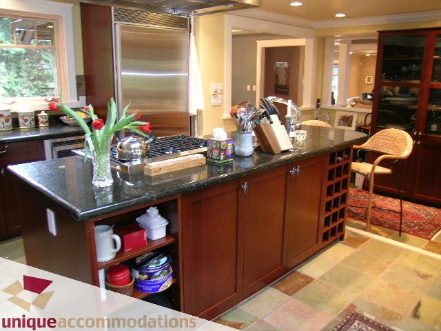 Bright kitchen with granite countertops, stainless steel appliances, and a cozy dining area. - 4497 Marine Dr., West Vancouver