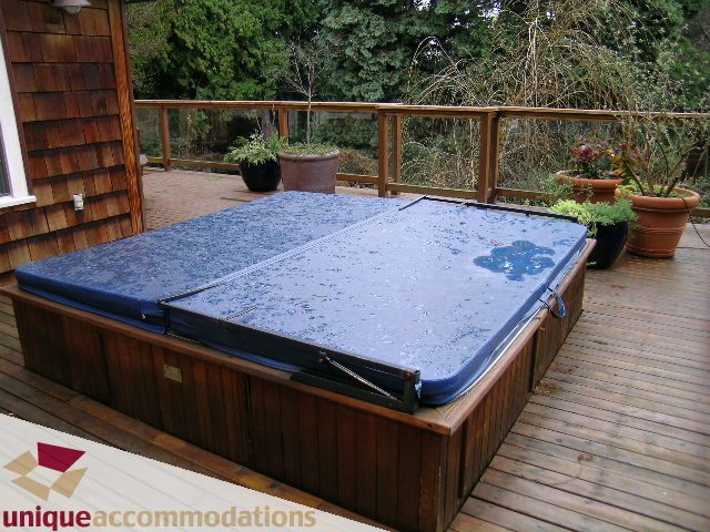Furnished hot tub on wooden deck with potted plants. - 4497 Marine Dr., West Vancouver