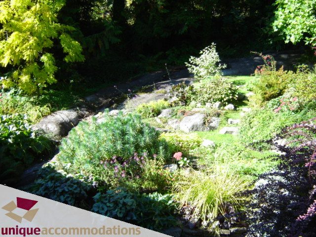 Furnished garden with stone pathways and lush greenery. - 4497 Marine Dr., West Vancouver