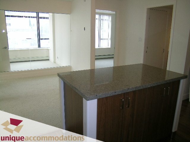 Bright kitchen with granite countertops and hardwood floors, city view from the living area. - 108 - 175 West 1st Street, North Vancouver