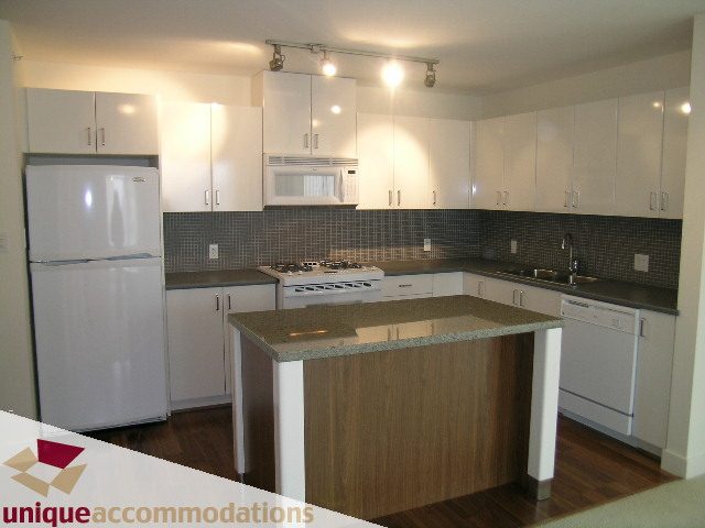 Bright kitchen with white cabinets, granite countertops, and hardwood floors. - 108 - 175 West 1st Street, North Vancouver