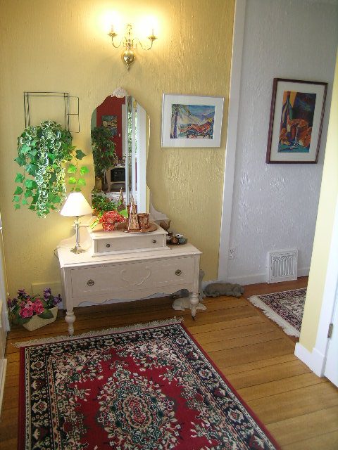 Cozy living room with hardwood floors, a red rug, and a hanging plant. - 2679 Ottawa Ave, West Vancouver