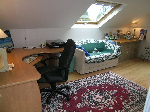Cozy attic den with hardwood floors, a skylight, a desk, and a comfortable couch. - 2679 Ottawa Ave, West Vancouver