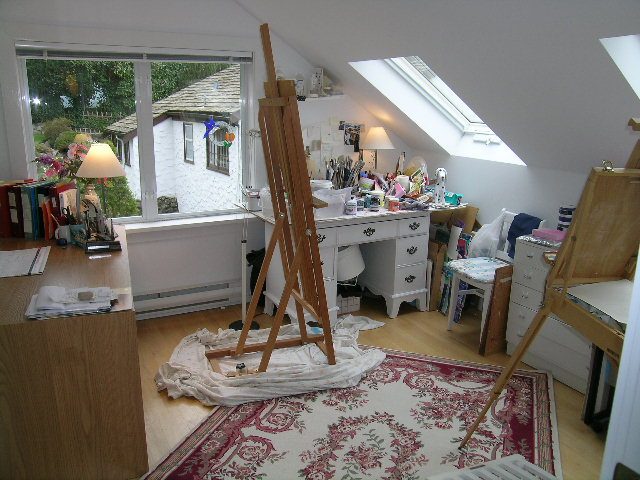 Art studio with easels, cluttered workspace, and patterned rug. - 2679 Ottawa Ave, West Vancouver