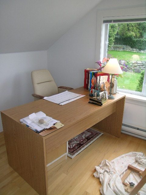 Spacious home office with wooden desk, hardwood floors, and a view of the garden. - 2679 Ottawa Ave, West Vancouver