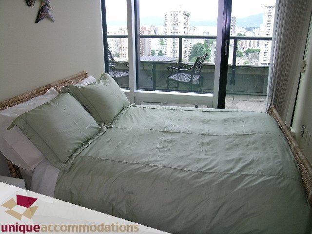 Furnished 1-bedroom + den with a cozy bed and a city view from the balcony. - 1807 - 1003 Burnaby Street, Vancouver Downtown
