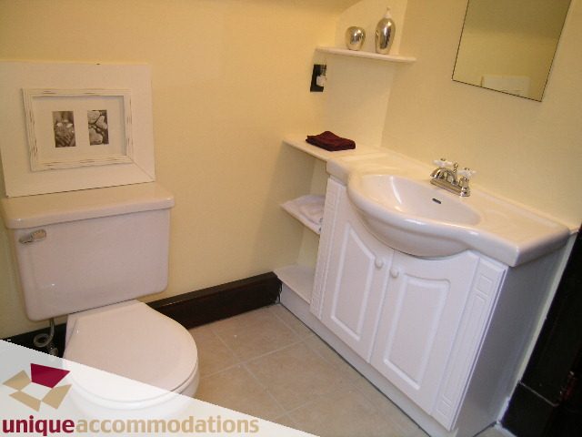 Bright bathroom with white sink, countertop, and framed artwork. - PH - 2812 Yukon St, Vancouver West Side