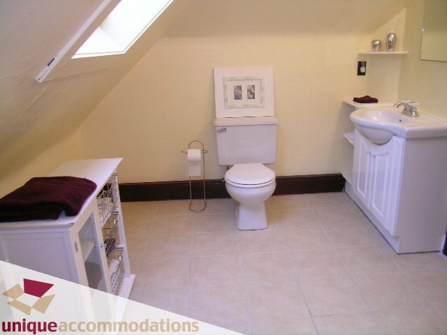 Bright bathroom with white fixtures and beige tile flooring. - PH - 2812 Yukon St, Vancouver West Side