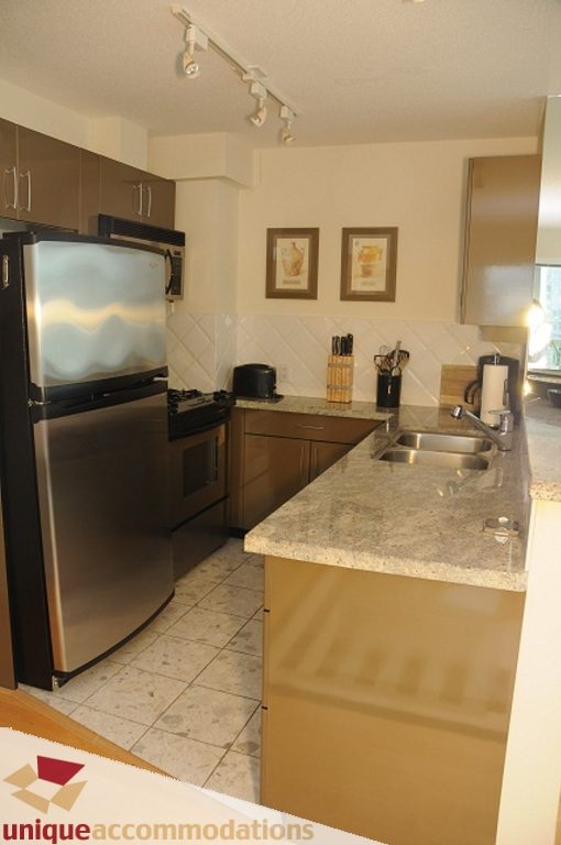 Modern kitchen with granite countertops and stainless steel appliances, perfect for a cozy downtown condo.