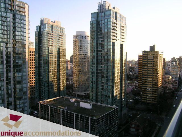 Spacious 1-bedroom + den condo with stunning city view, featuring modern furnishings and large windows.