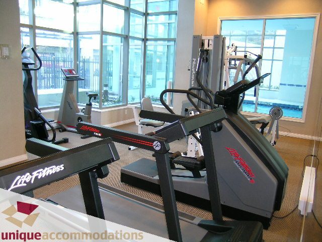 Fitness room with cardio equipment and large windows offering a city view. - 3101 - 1328 W. Pender Street, Vancouver Downtown