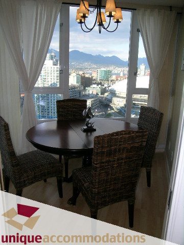 Furnished dining area with city view and hardwood floors. - 3101 - 1033 Marinaside Crescent, Vancouver Downtown