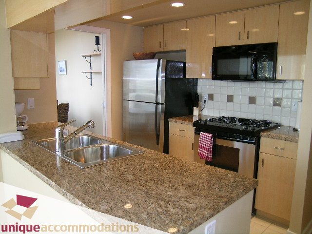 Bright kitchen with granite countertops and stainless steel appliances, perfect for a cozy downtown condo.