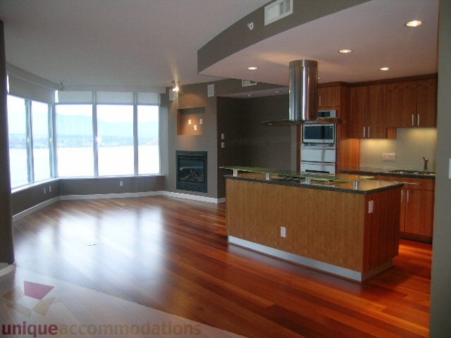 Bright kitchen with hardwood floors and city view, featuring granite countertops and stainless steel appliances.