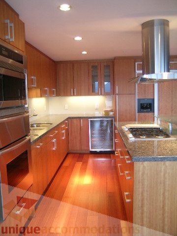 Bright kitchen with wooden cabinets, granite countertops, and stainless steel appliances. - 2101 - 1281 West Cordova Street, Vancouver Downtown