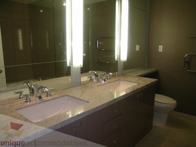 Furnished bathroom with modern vanity, marble countertop, and large mirror. - 2101 - 1281 West Cordova Street, Vancouver Downtown