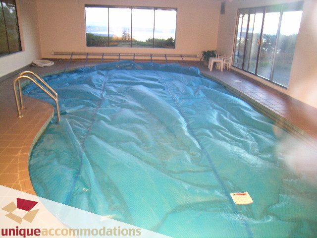 Covered pool area with large windows and tiled floor. - 1416 Chartwell Drive, West Vancouver