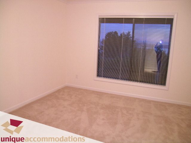 Spacious bedroom with carpeted floor and large window view. - 1416 Chartwell Drive, West Vancouver
