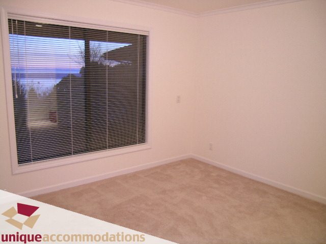 Bright bedroom with large windows and carpeted floor. - 1416 Chartwell Drive, West Vancouver