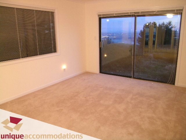 Bright living room with large sliding glass doors and city view. - 1416 Chartwell Drive, West Vancouver