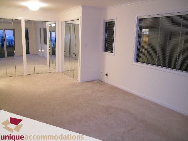 Spacious bedroom with mirrored closet doors and large windows. - 1416 Chartwell Drive, West Vancouver