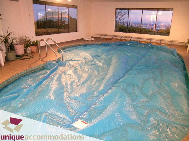 Covered indoor pool with city view and tiled floor. - 1416 Chartwell Drive, West Vancouver