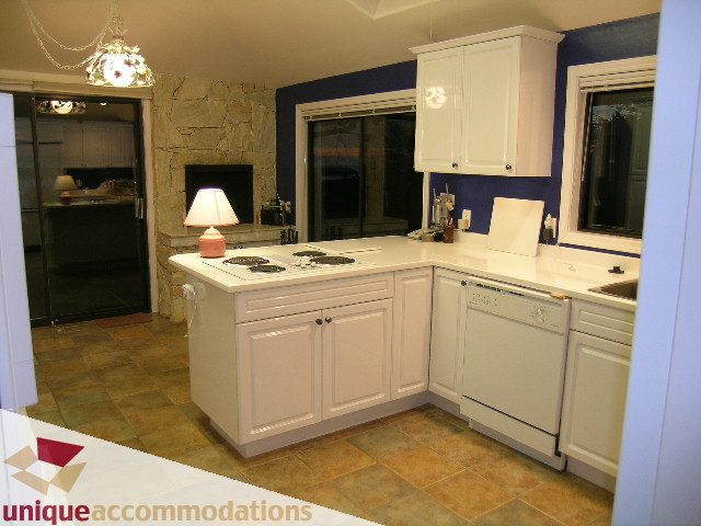 Bright kitchen with white cabinets, granite countertops, and tiled floors. - 1416 Chartwell Drive, West Vancouver