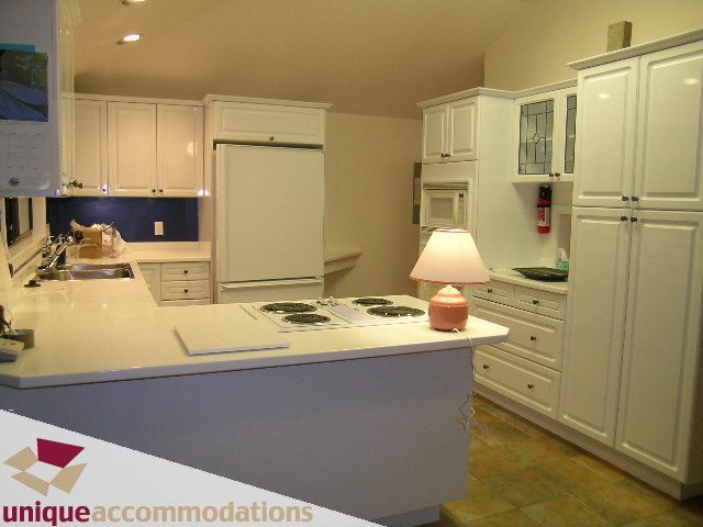 Bright kitchen with white cabinets, granite countertops, and a tiled backsplash. - 1416 Chartwell Drive, West Vancouver