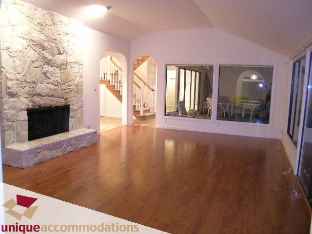 Open living area with hardwood floors and stone fireplace. - 1416 Chartwell Drive, West Vancouver