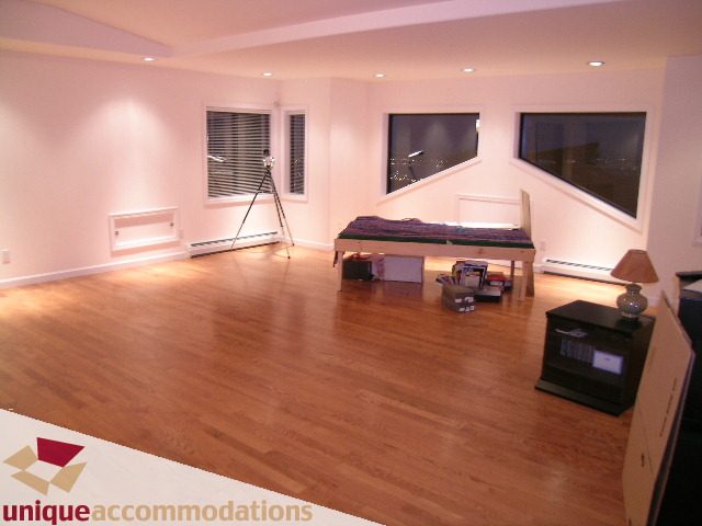 Bright living room with hardwood floors and city view windows. - 1416 Chartwell Drive, West Vancouver